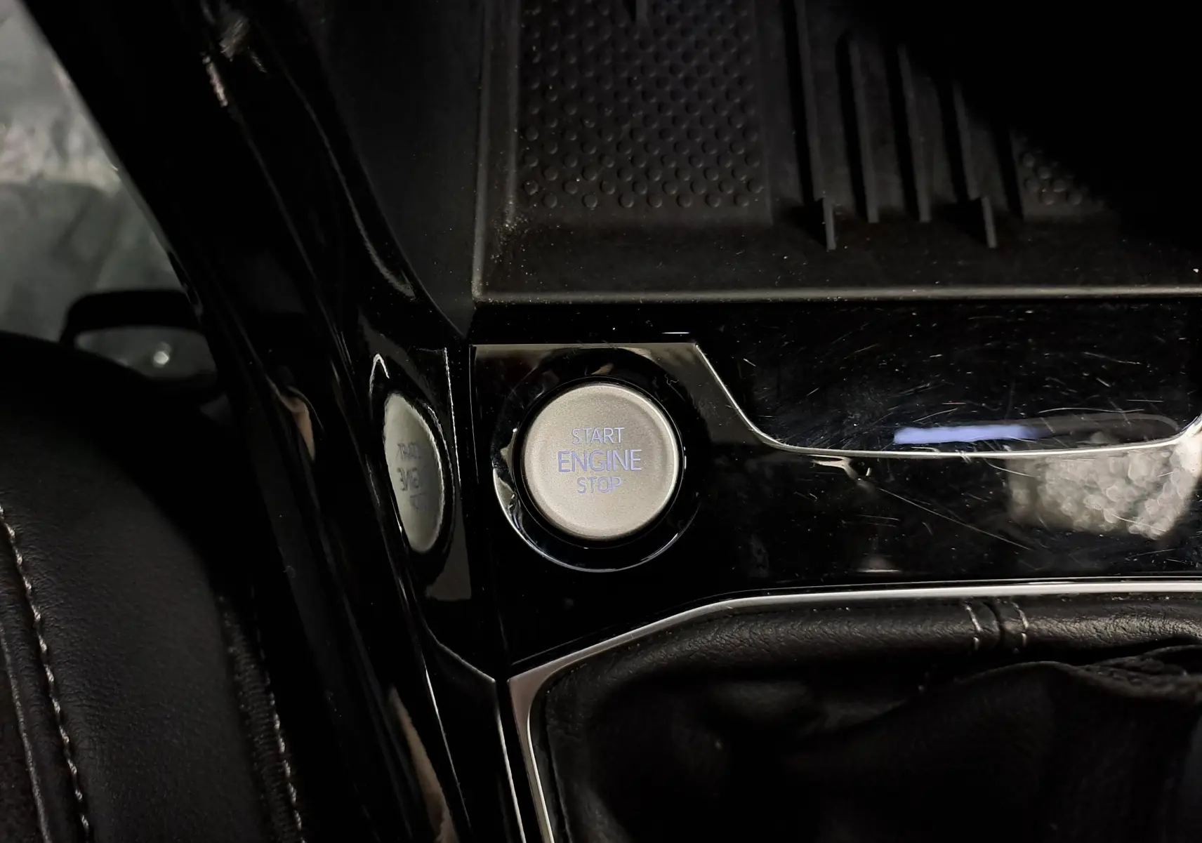 Bouton start/stop moteur en gros plan sur la console centrale noire brillante du Volkswagen T-Cross 2025 R-Line Edition.