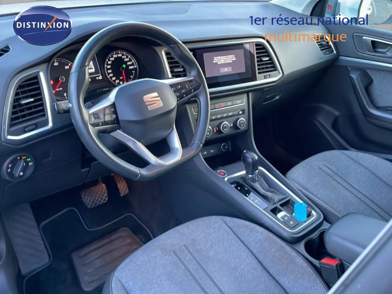 Vue intérieure avant droite du SEAT Ateca 2022 avec tableau de bord noir et sièges tissu gris.