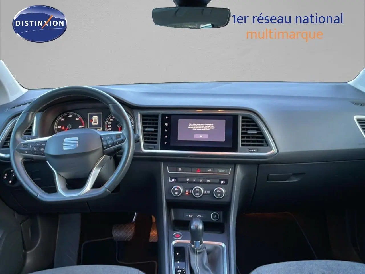 Vue intérieure frontale du tableau de bord et volant noir du SEAT Ateca 2022 avec écran tactile central et levier de vitesse automatique.