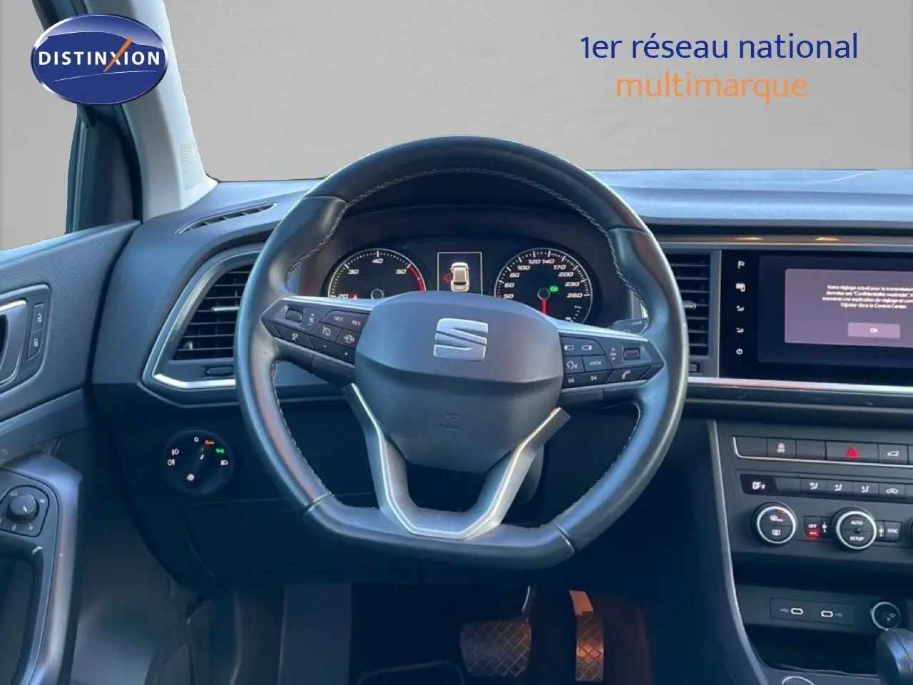 Vue intérieure centrée sur le volant cuir noir du SEAT Ateca 2022, avec tableau de bord et écran multimédia visibles.