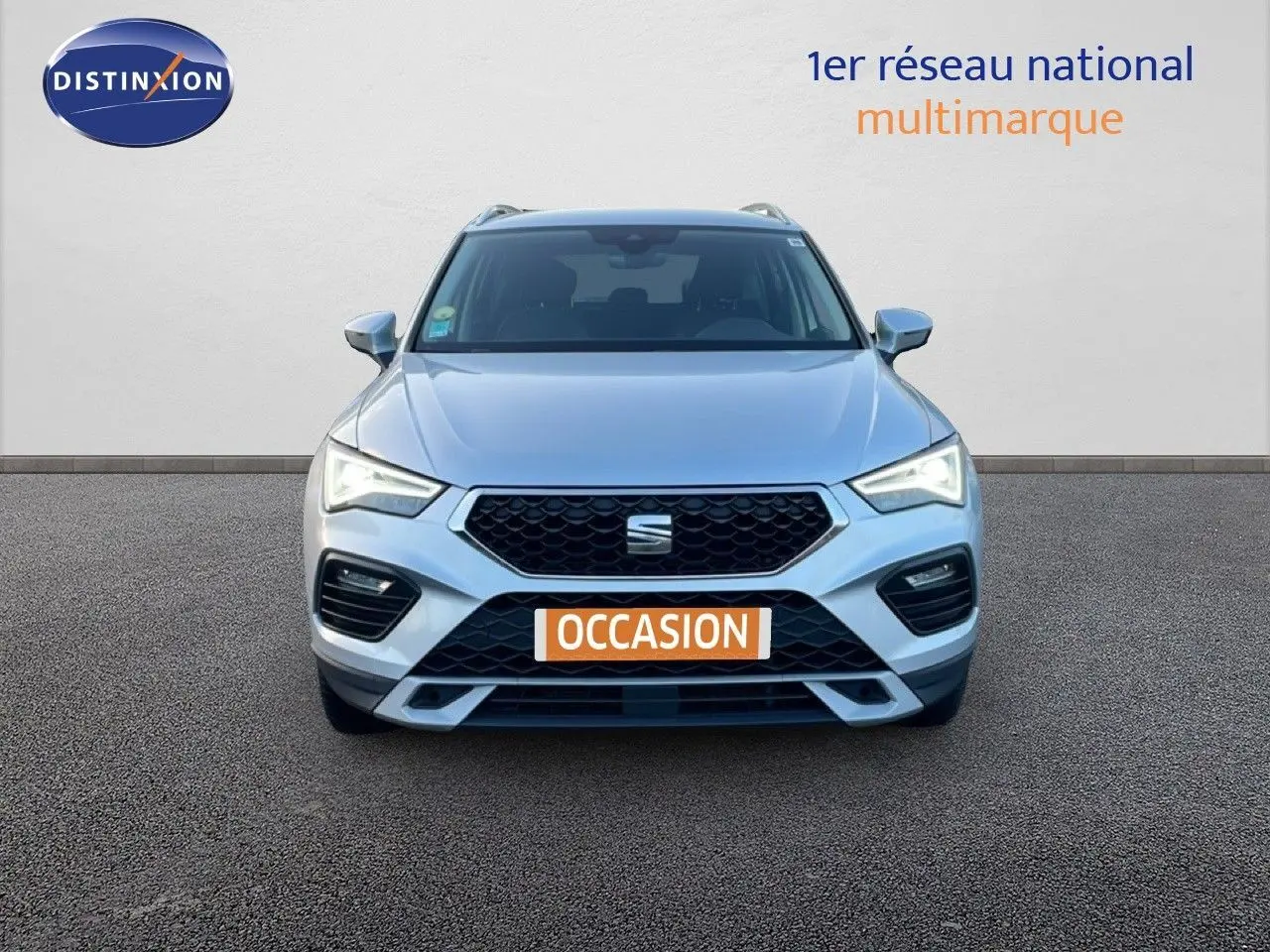 Vue frontale d'un SEAT Ateca 2022 argent Reflex Metal avec calandre noire et feux LED allumés.