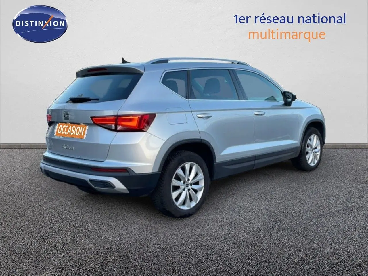 Vue 3/4 arrière droite d'un SEAT Ateca 2022 argent Reflex Metal avec jantes alliage et feux LED allumés.