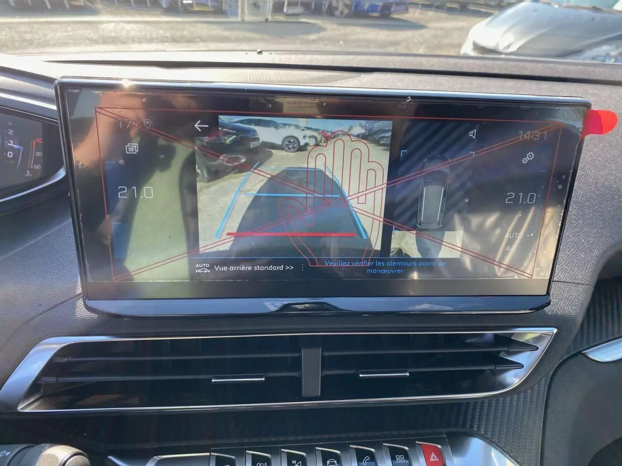 Vue rapprochée de l'écran tactile du Peugeot 5008 gris platinium montrant l'aide au stationnement arrière avec alertes graphiques.