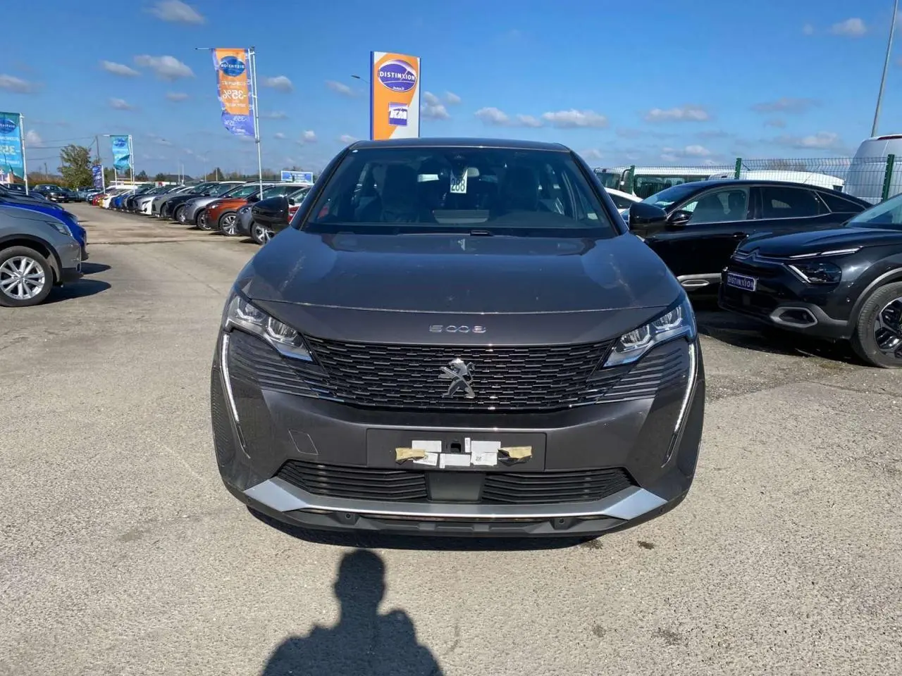 Vue avant d'un Peugeot 5008 gris platinium métallisé, avec calandre noire et feux LED distinctifs.