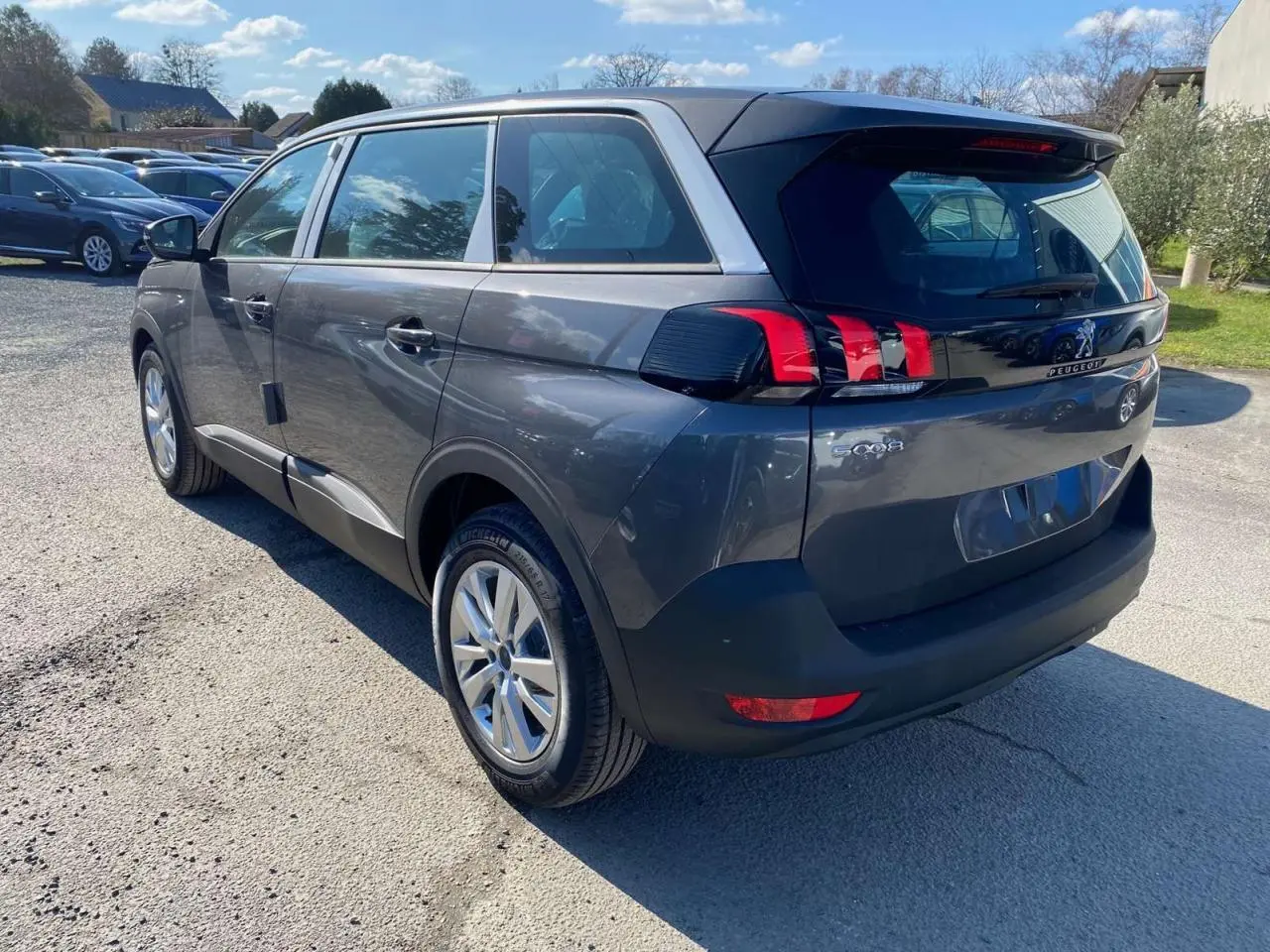 Vue 3/4 arrière droit d’un Peugeot 5008 gris platinium métallisé avec feux arrière LED et jantes alliage 17 pouces.