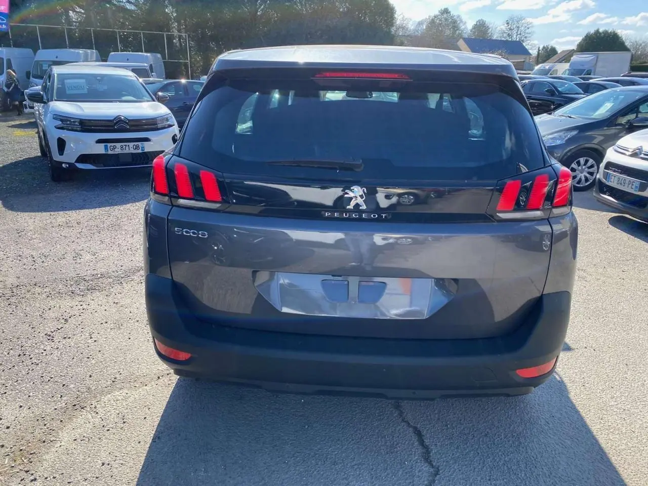 Vue arrière d'un Peugeot 5008 gris platinium métal avec feux arrière LED distinctifs en forme de griffes.