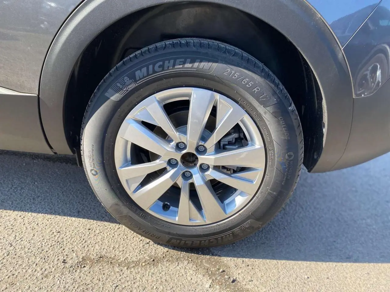 Gros plan sur la roue avant droite d’un Peugeot 5008 gris platinium métal avec jante alliage 17 pouces Chicago.