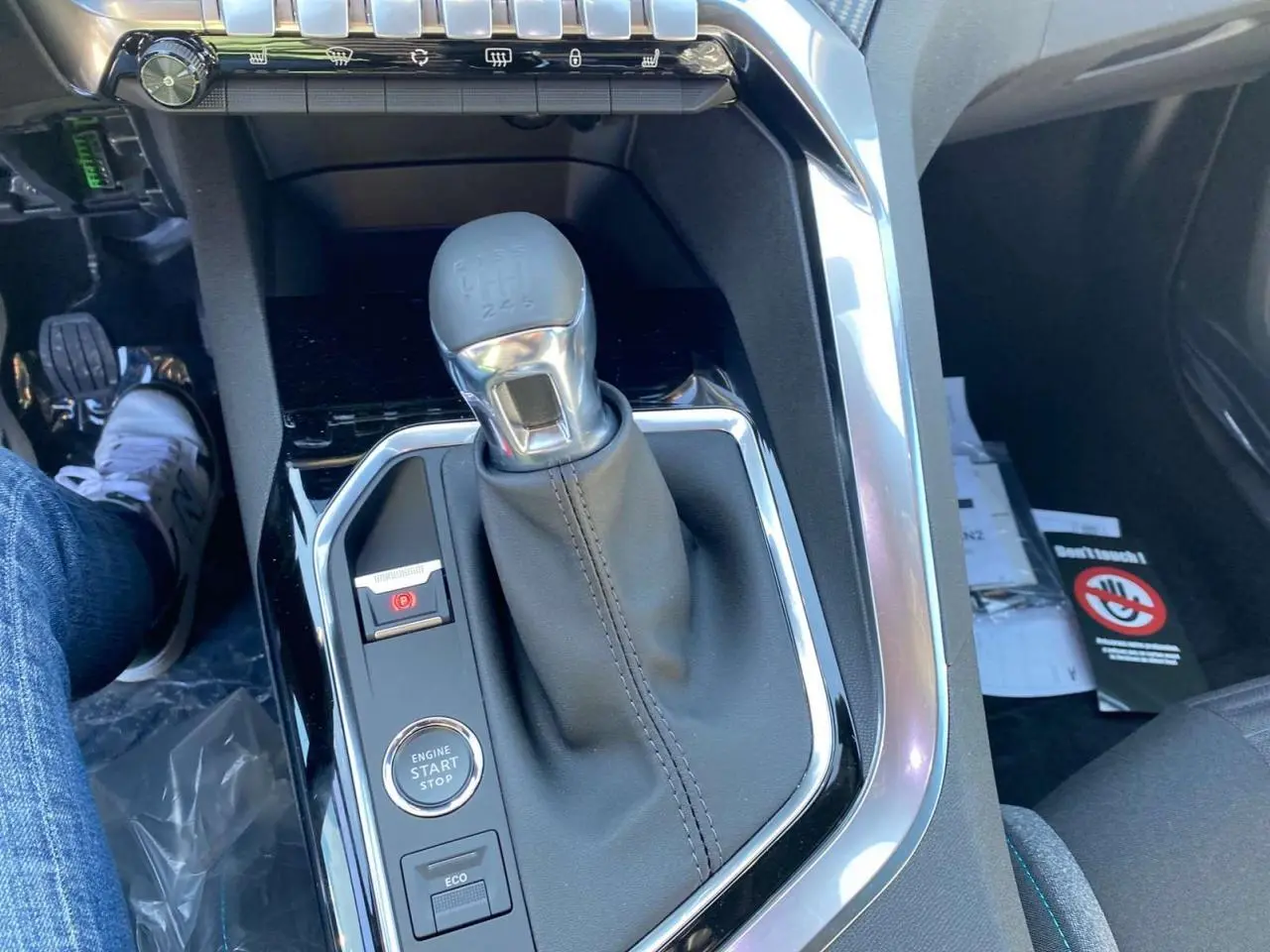 Gros plan sur la console centrale du Peugeot 5008 gris platinium, avec levier de vitesses manuel et bouton start/stop.