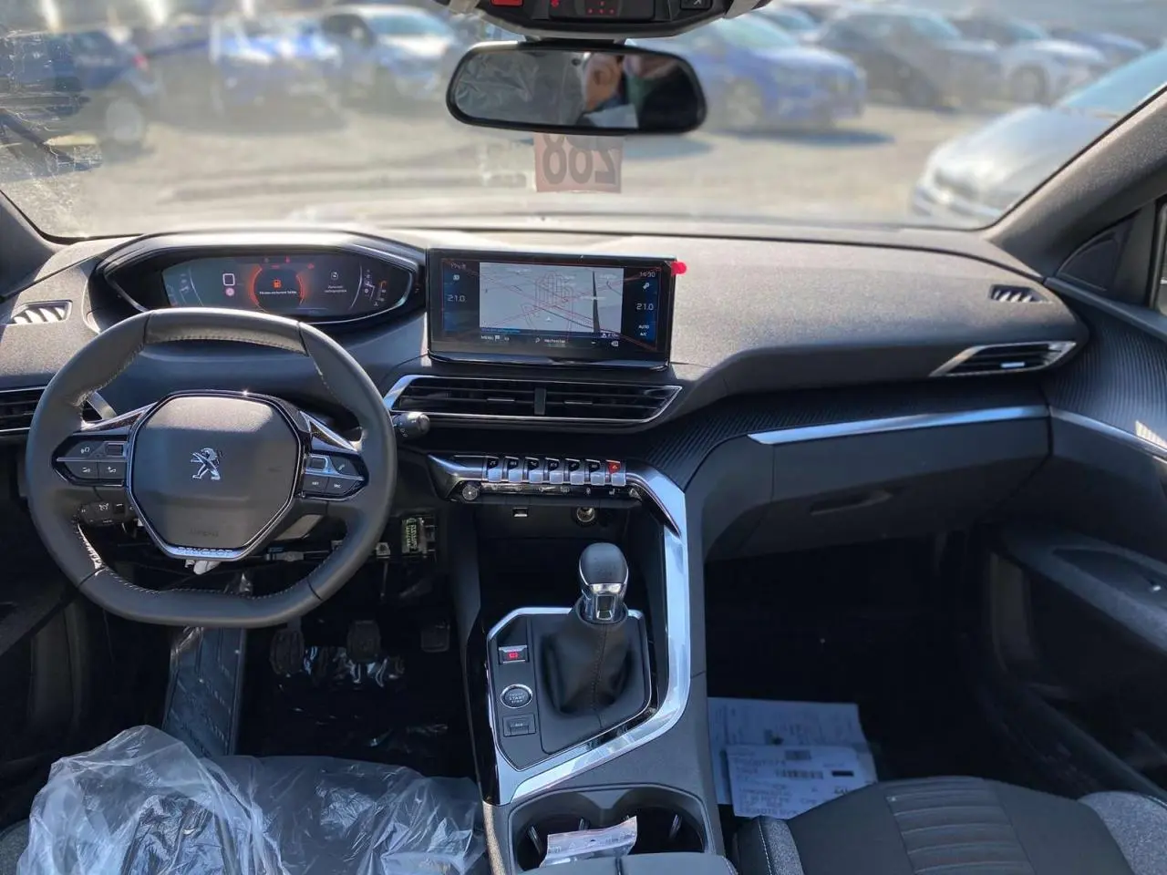 Vue intérieure avant du Peugeot 5008 gris platinium, mettant en valeur le tableau de bord numérique et l’écran tactile central.