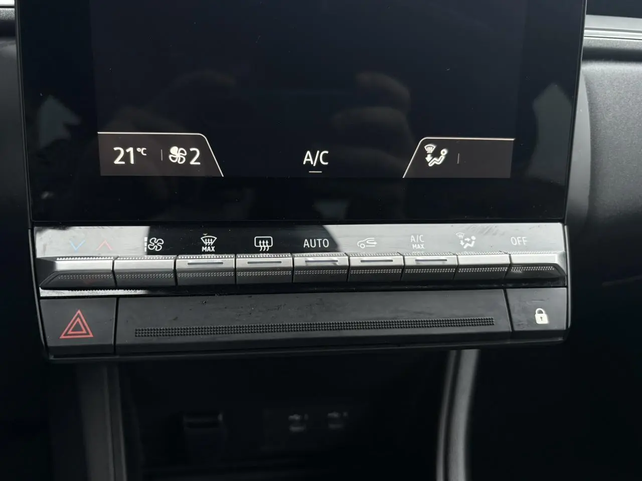 Détail de la console centrale du Renault Captur TCE 100 Techno 2025, montrant les commandes de climatisation automatique.