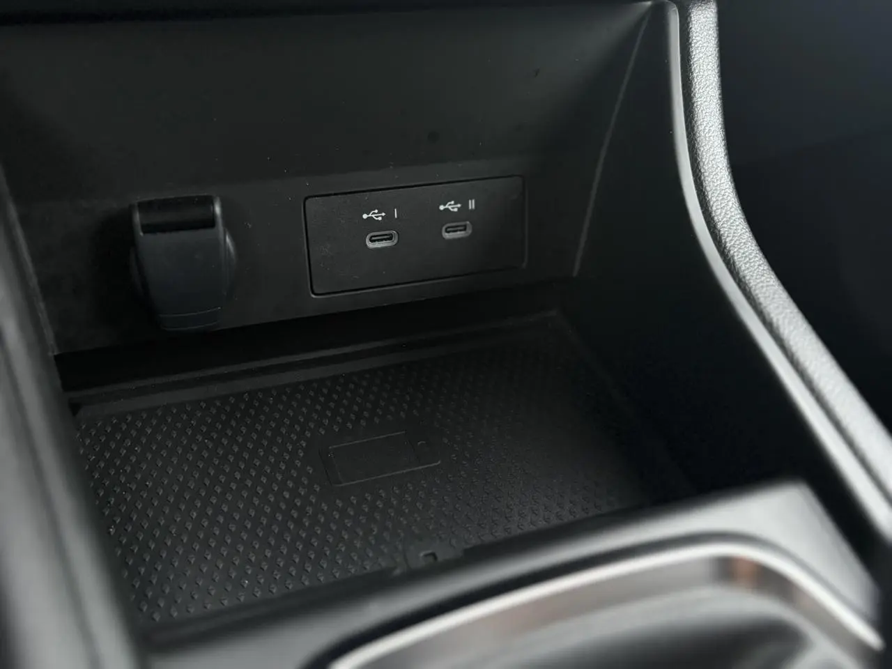 Gros plan sur la console centrale du Renault Captur TCE 100 Techno 2025, montrant les ports USB-C doubles et un espace de rangement noir.