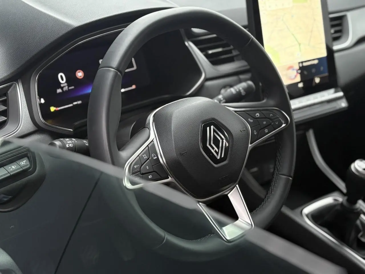 Vue rapprochée du volant noir et du tableau de bord numérique du Renault Captur TCE 100 Techno 2025 avec écran tactile GPS.