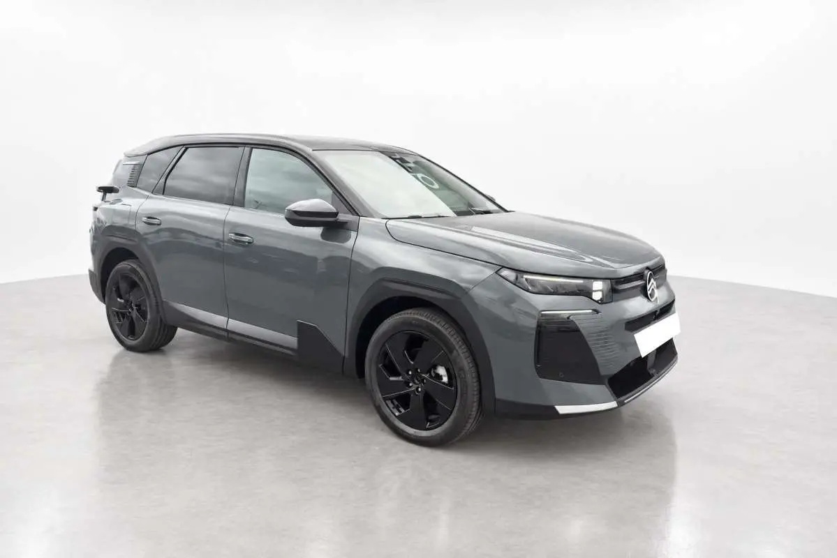 Vue 3/4 avant droit d'un Citroën C5 Aircross gris métallisé avec jantes noires et vitres teintées.
