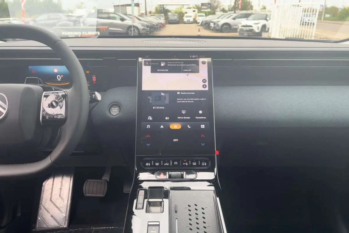Vue intérieure centrée sur la console centrale tactile et le volant cuir du Citroën C5 Aircross Hybrid 2026.