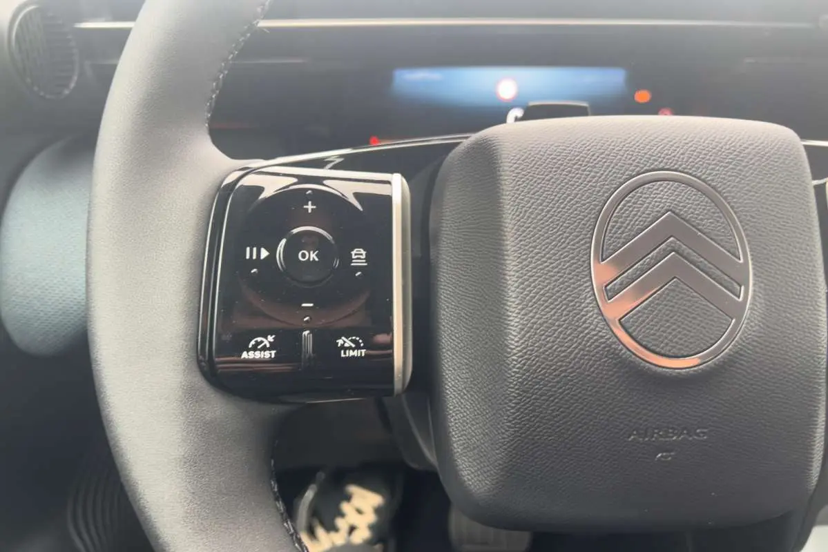 Gros plan sur le volant cuir multifonctions du Citroën C5 Aircross Hybrid 145 Plus, avec commandes intégrées.