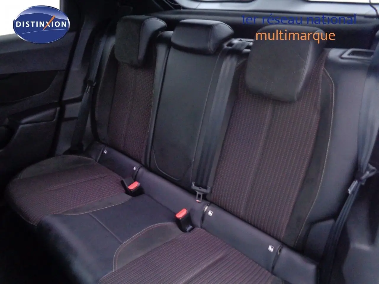 Vue intérieure sur la banquette arrière du DS3 Crossback avec sièges en tissu et cuir noir, appuie-têtes et ceintures visibles.