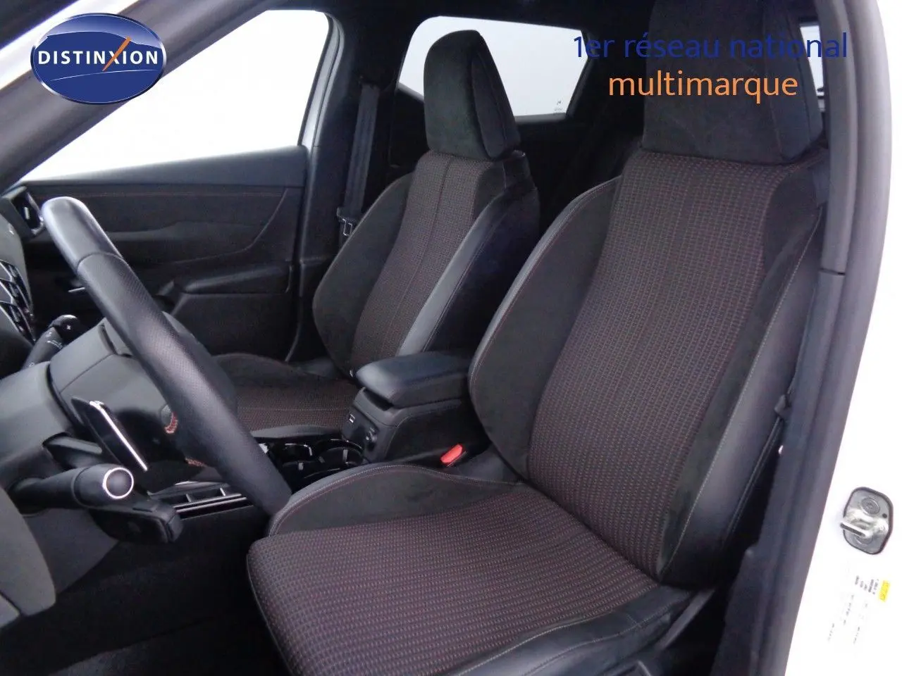 Vue intérieure côté conducteur du DS3 Crossback blanc Banquise, sièges tissu et alcantara noirs avec surpiqûres rouges.