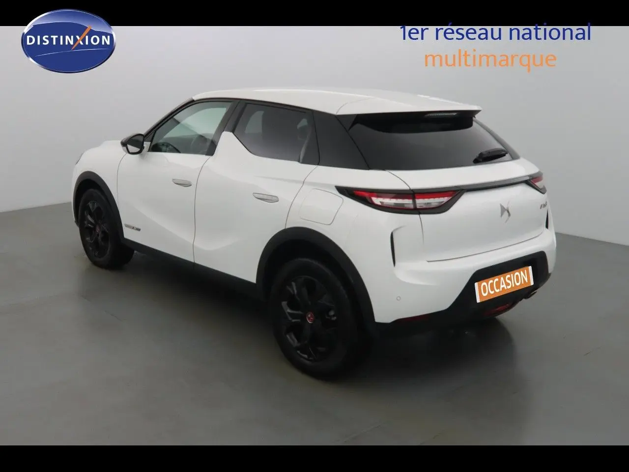 DS3 Crossback blanc banquise en 3/4 arrière droit, jantes noires et toit contrasté noir dans un studio.