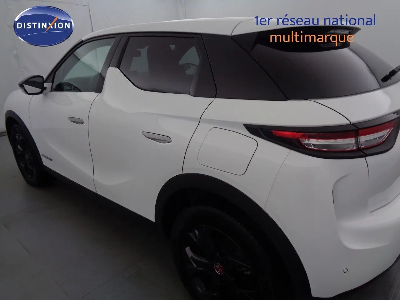 Vue 3/4 arrière droit du DS3 Crossback blanc banquise avec toit noir et jantes noires distinctives.