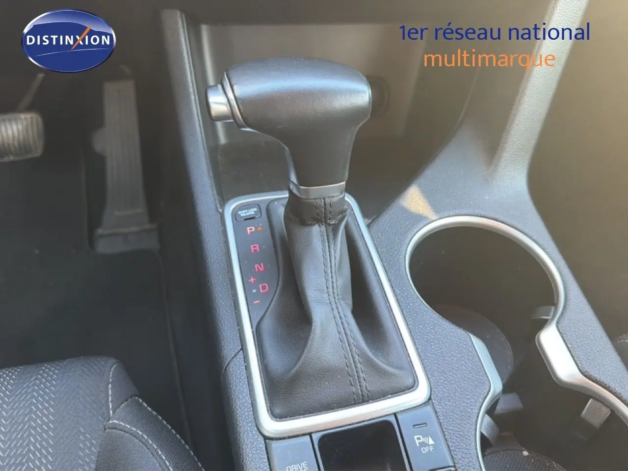 Le levier de vitesses automatique noir du Kia Sportage 2021, vue rapprochée de la console centrale avec porte-gobelet.