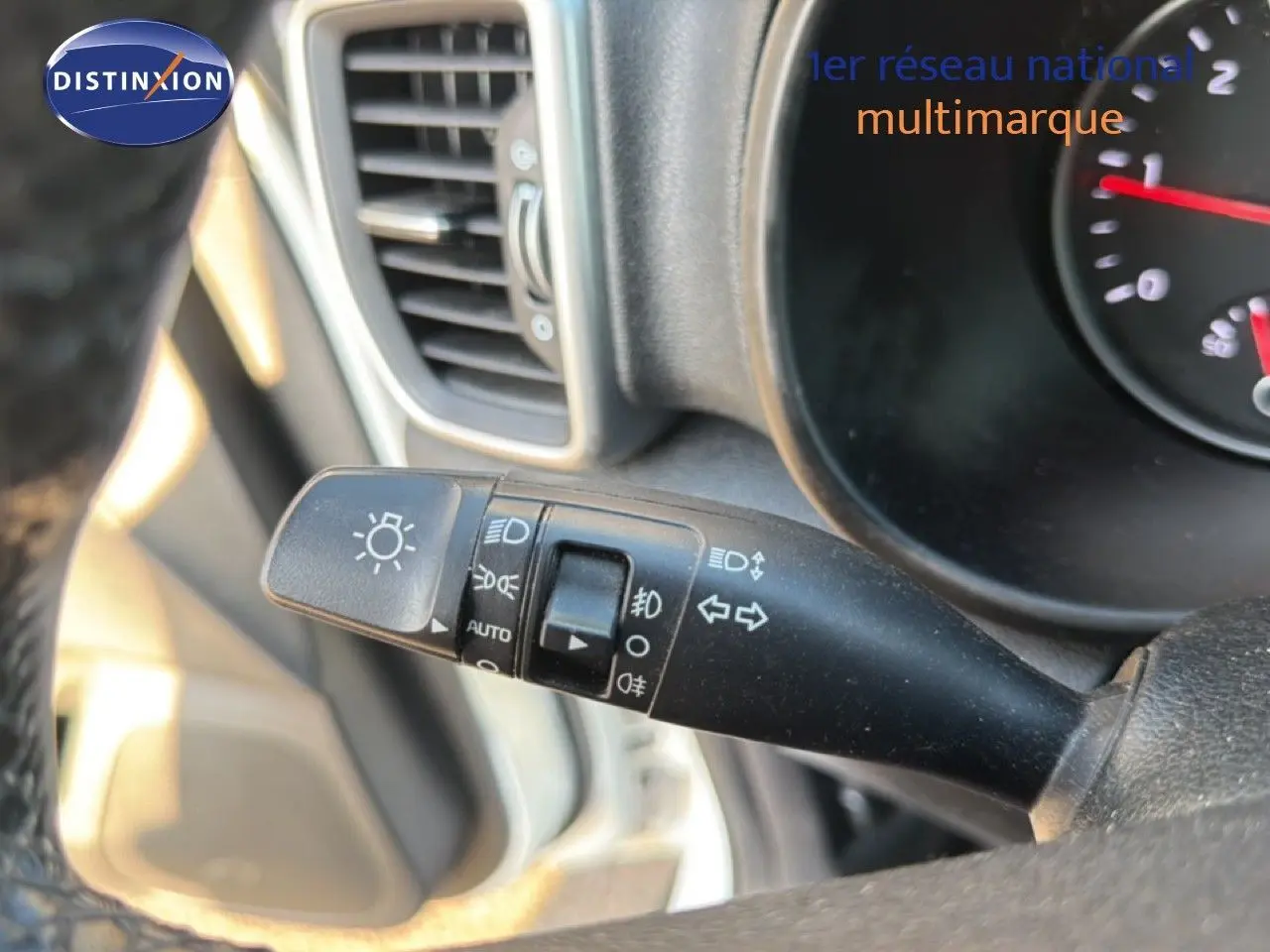 Gros plan sur la manette des feux et clignotants du tableau de bord d’un KIA Sportage blanc nacré 2021.