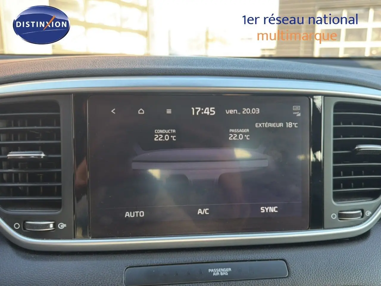 Écran tactile central du tableau de bord du Kia Sportage 2021, affichant la climatisation à 22°C, entouré de grilles d'aération noires.