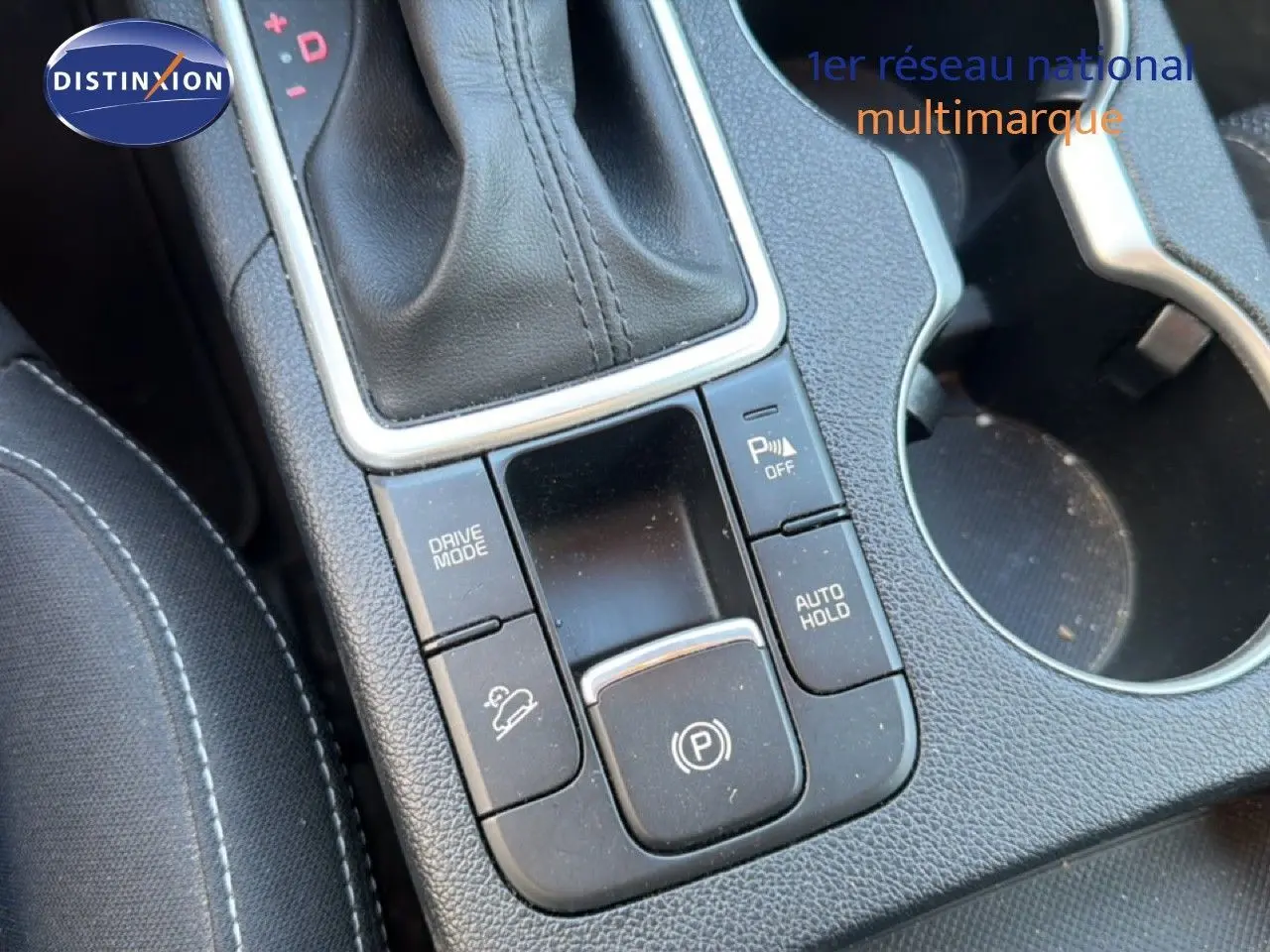 Gros plan sur la console centrale noire du Kia Sportage 2021, montrant la commande de boîte auto et les boutons de fonctions.