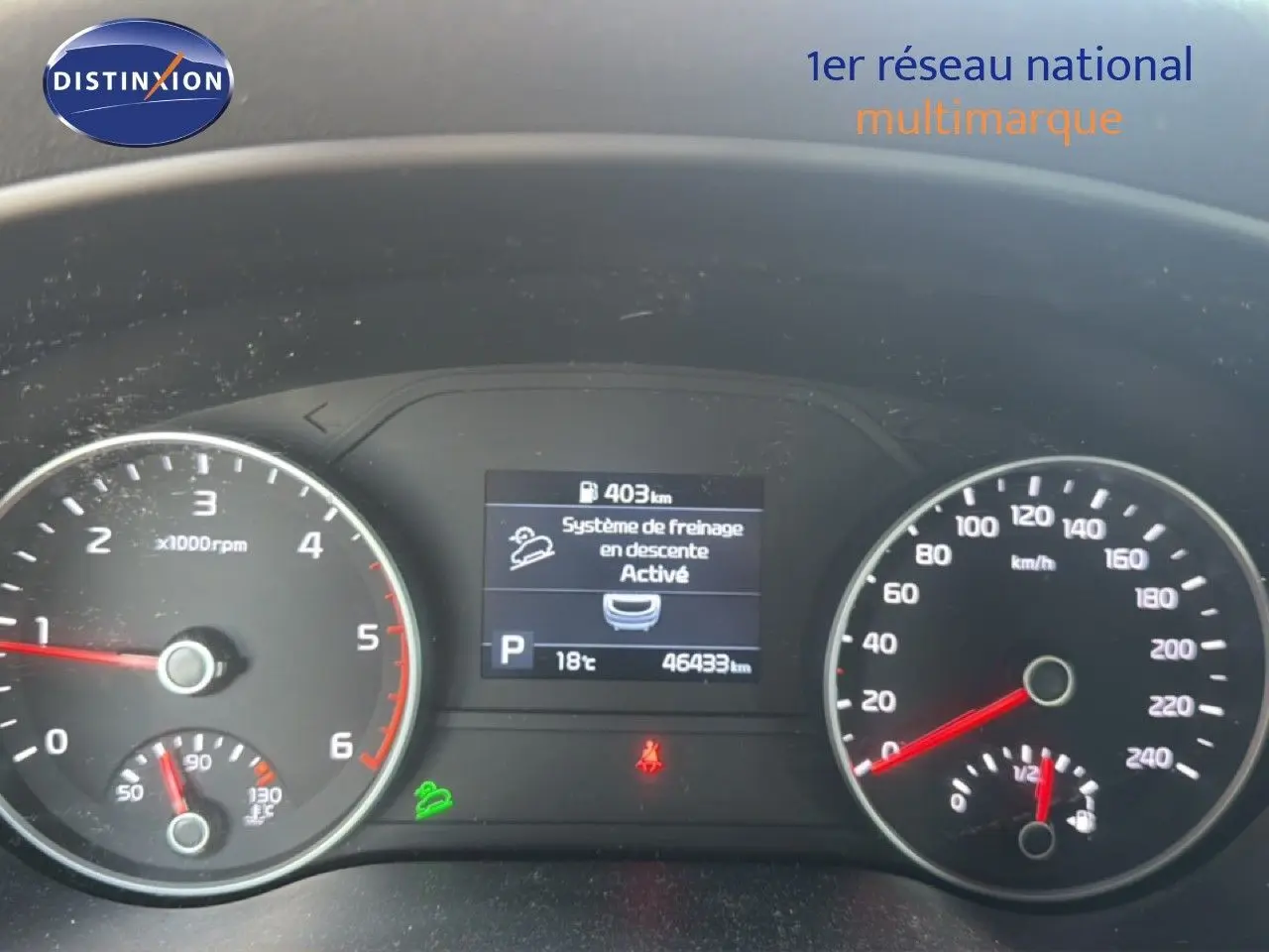 Vue rapprochée du tableau de bord du Kia Sportage blanc nacré 2021, affichant le compteur et l'écran central numérique.