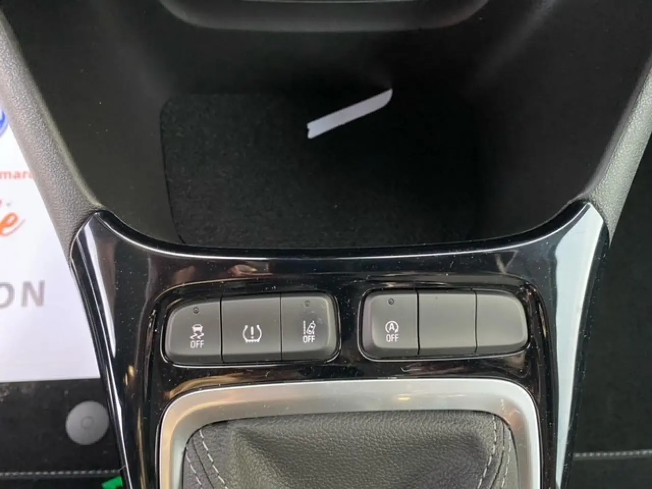 Gros plan sur la console centrale noire brillante de l'Opel Crossland 2022, montrant les boutons de contrôle et le soufflet de levier de vitesse.