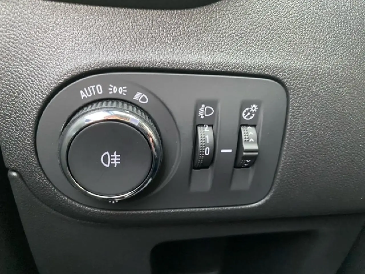 Gros plan sur les commandes d’éclairage intérieures de l’Opel Crossland gris alu, avec molette et réglages lumineux.