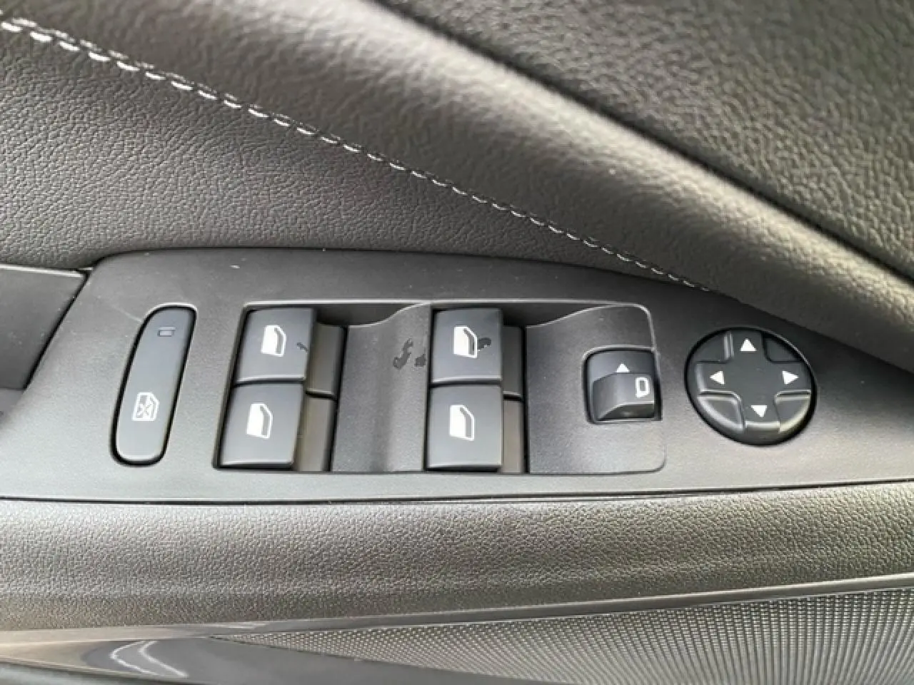 Gros plan sur les commandes de lève-vitres et réglage des rétroviseurs côté conducteur de l'Opel Crossland 2022.