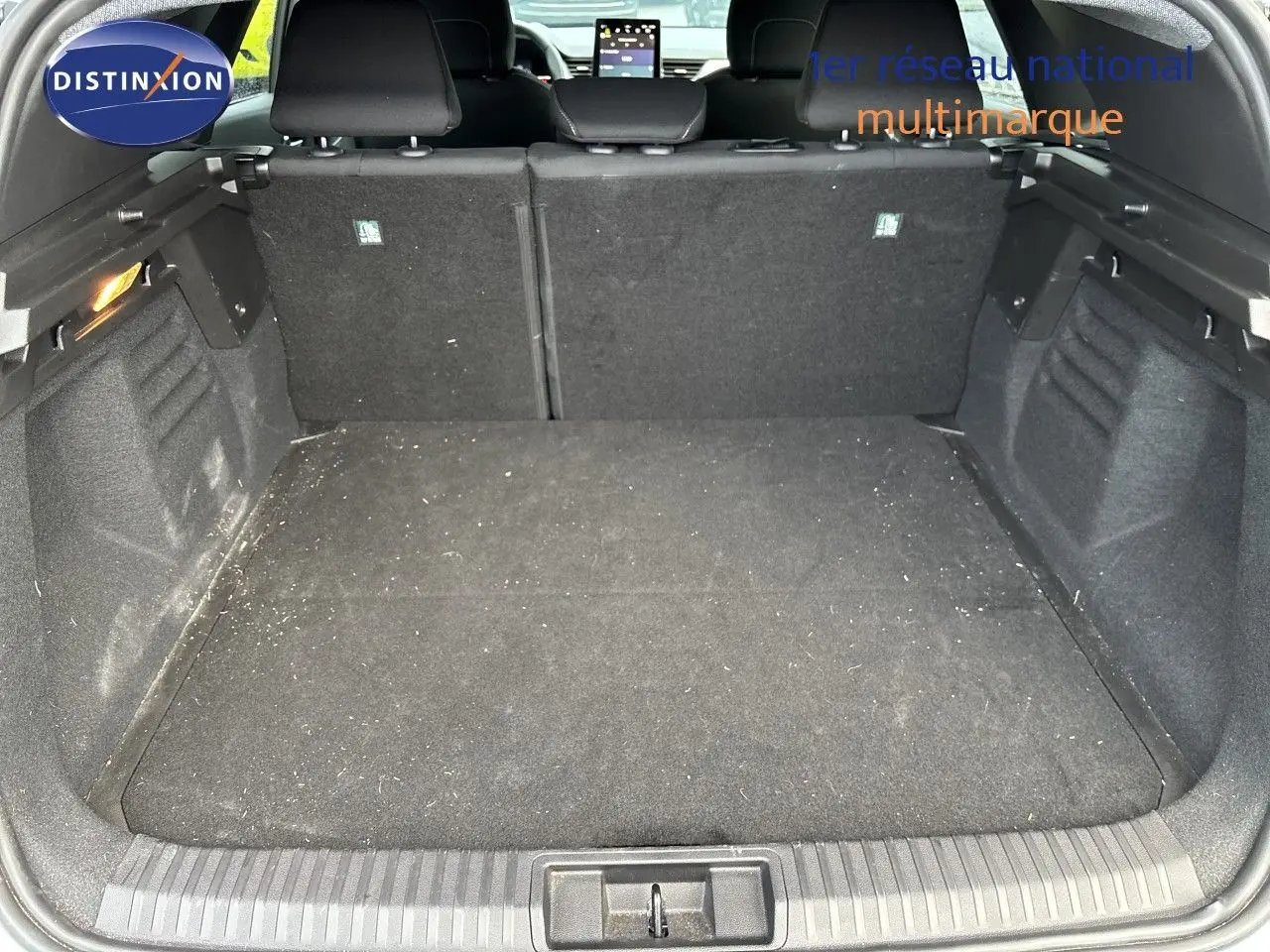 Vue intérieure du coffre spacieux du Renault Symbioz blanc nacré, avec banquette arrière en tissu noir visible.