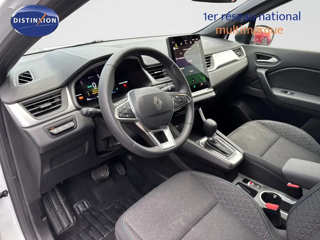 Intérieur avant droit du Renault Symbioz blanc nacré, volant multifonction, écran tactile vertical et sièges tissu gris.