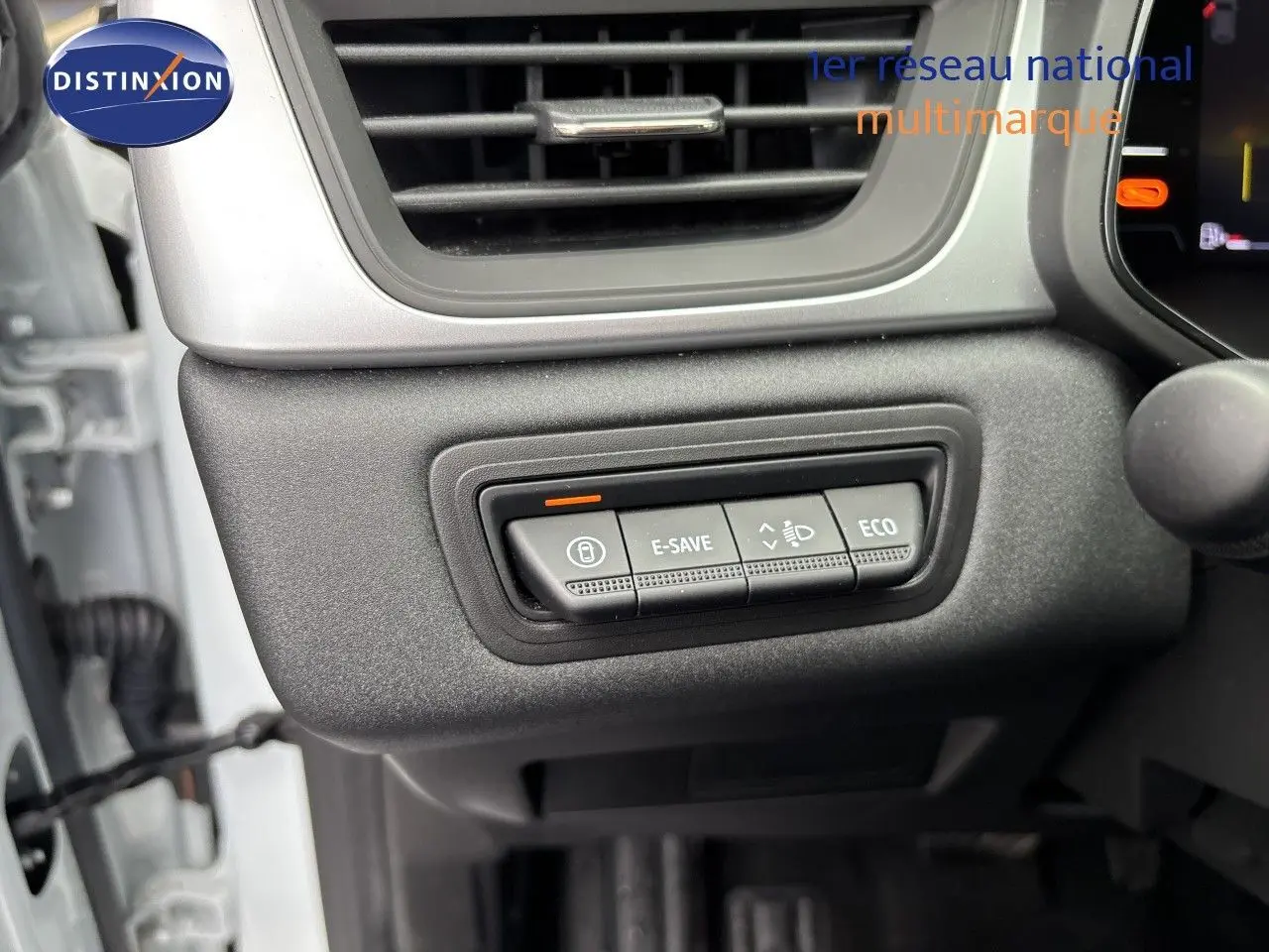 Gros plan sur les commandes de mode de conduite E-SAVE et ECO dans l'habitacle d'une Renault Symbioz blanc nacré.