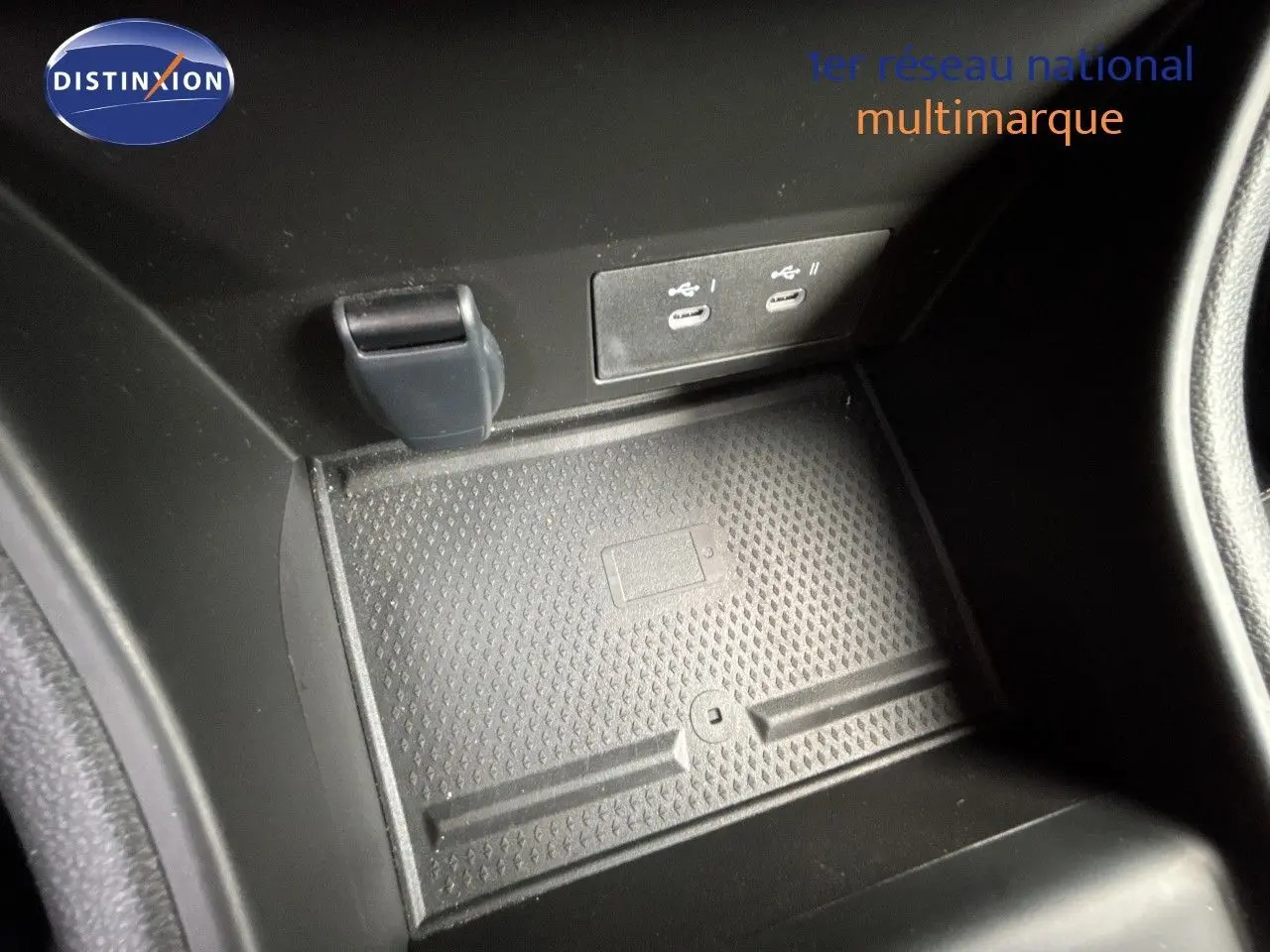 Gros plan sur la console centrale noire avec ports USB et surface antidérapante dans une Renault Symbioz blanc nacré.