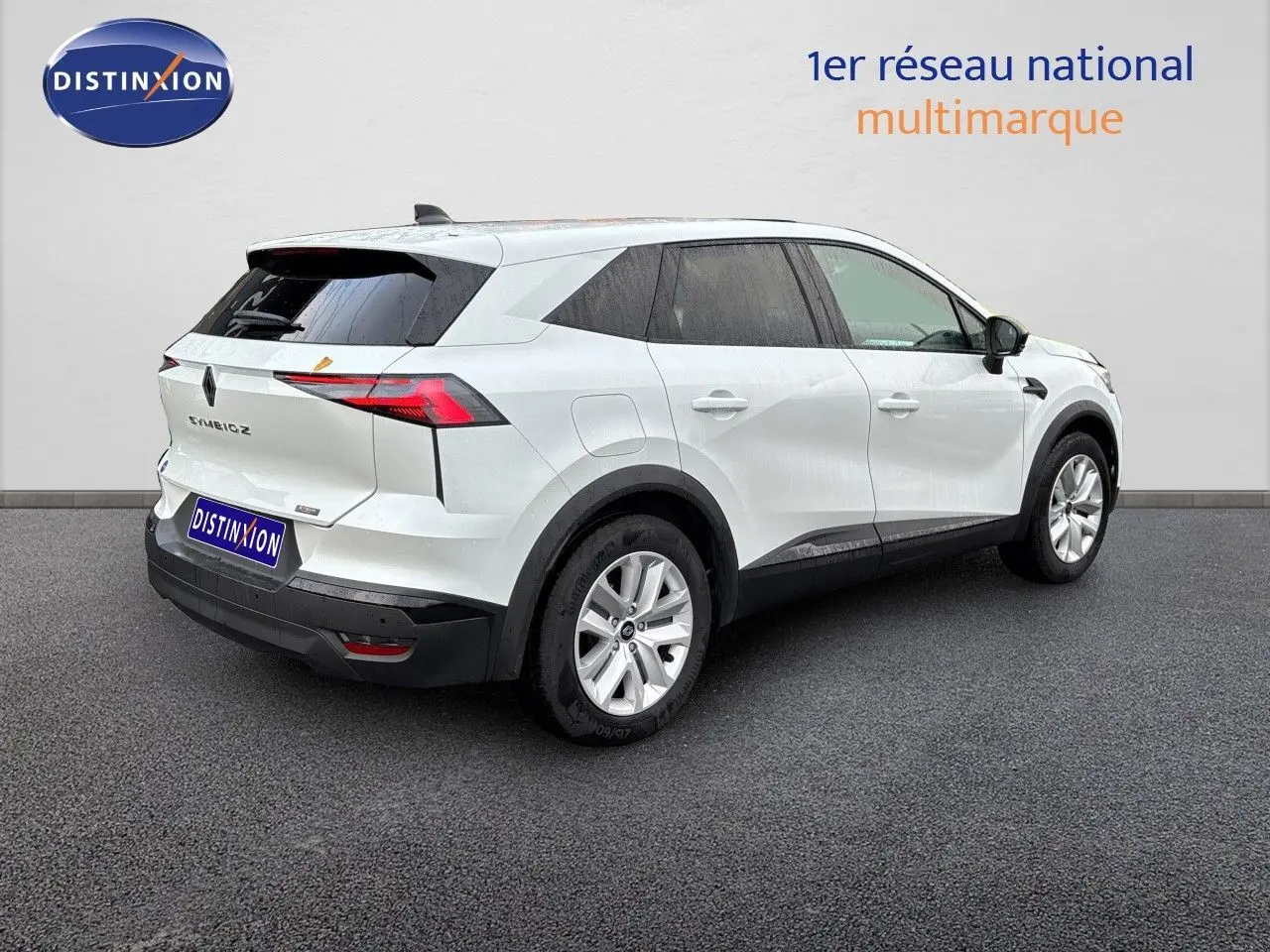Renault Symbioz blanc nacré métal vu en 3/4 arrière droit, avec feux arrière LED et jantes alliage.