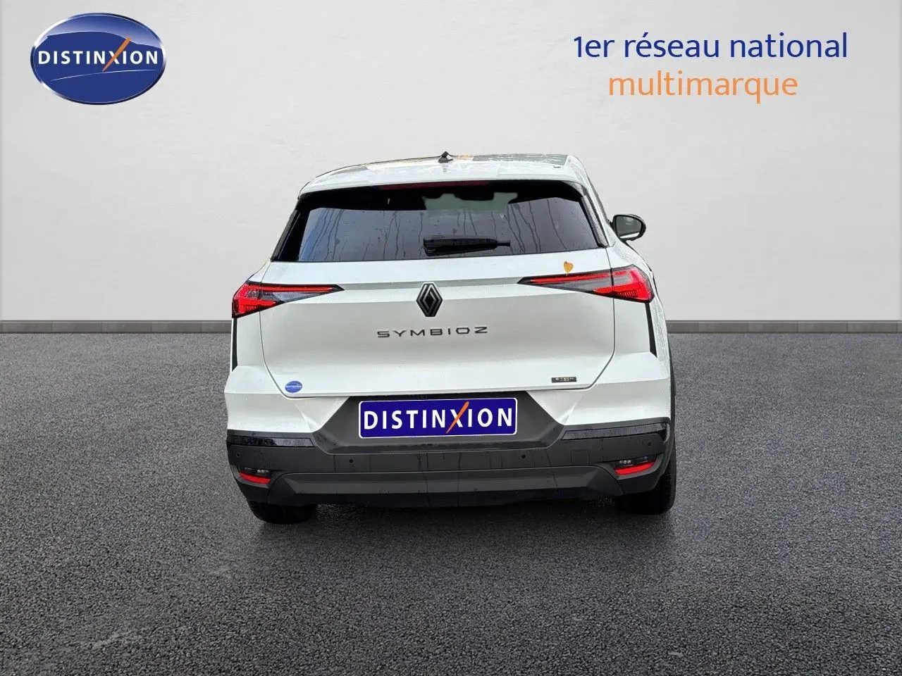 Vue arrière d'une Renault Symbioz blanc nacré métallisé, avec feux arrière fins et logo central bien visibles.