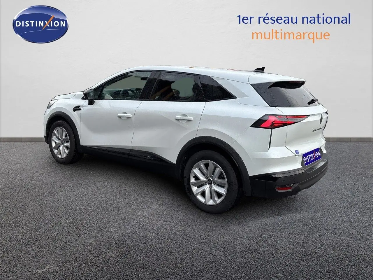 Renault Symbioz blanc nacré métal en vue 3/4 arrière droit, avec feux arrière LED et jantes alliage.