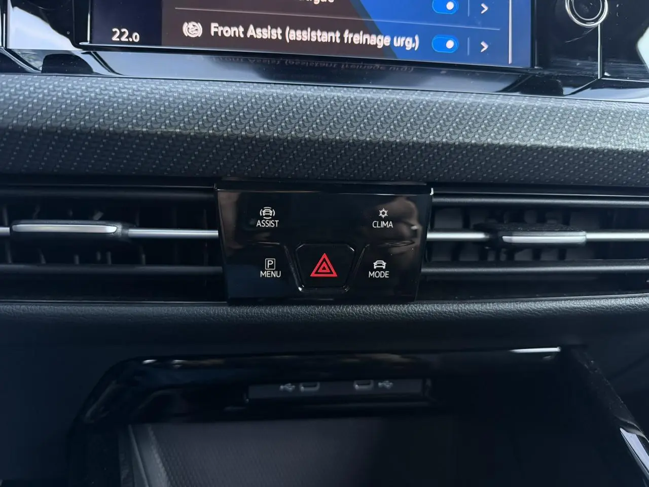 Détail du tableau de bord de la Volkswagen Golf 8 R-Line 2024, avec commandes d'assistance et climatisation.