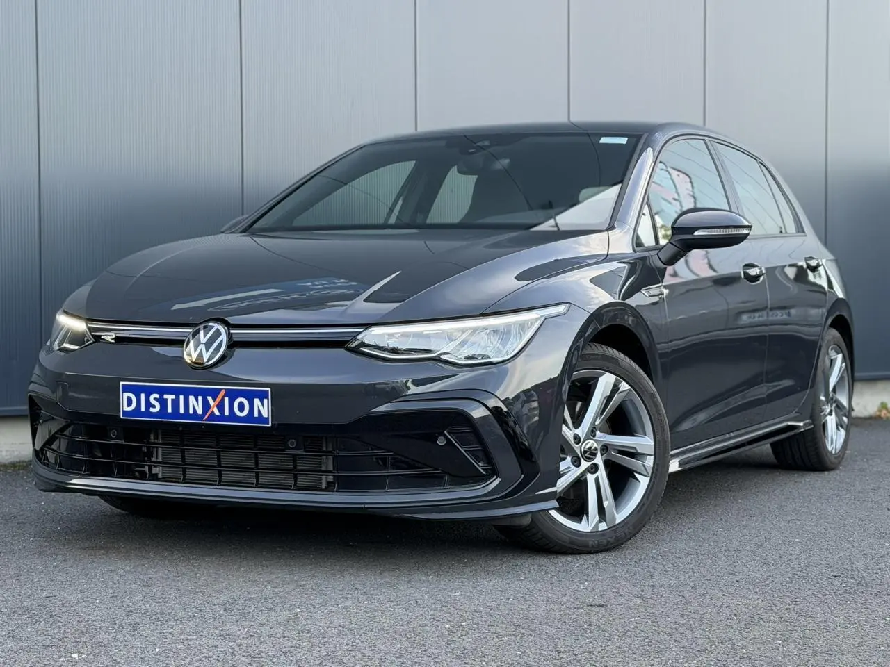 Volkswagen Golf 8 R-Line gris Urano vue 3/4 avant droit avec calandre noire brillante et jantes alliage 17 pouces.