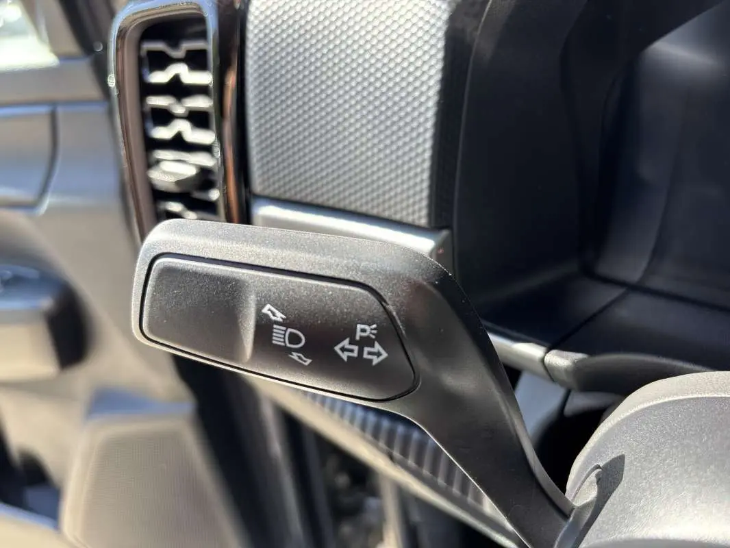 Gros plan sur la manette de clignotant noire à gauche du volant dans l'habitacle du Ford Ranger gris carbone 2026.