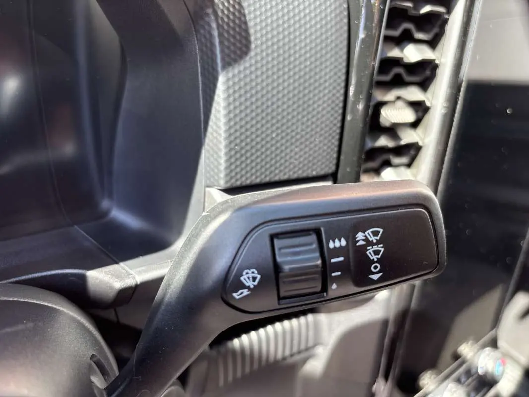 Gros plan sur la commande des essuie-glaces à gauche du volant dans l’habitacle du Ford Ranger gris carbone 2026.