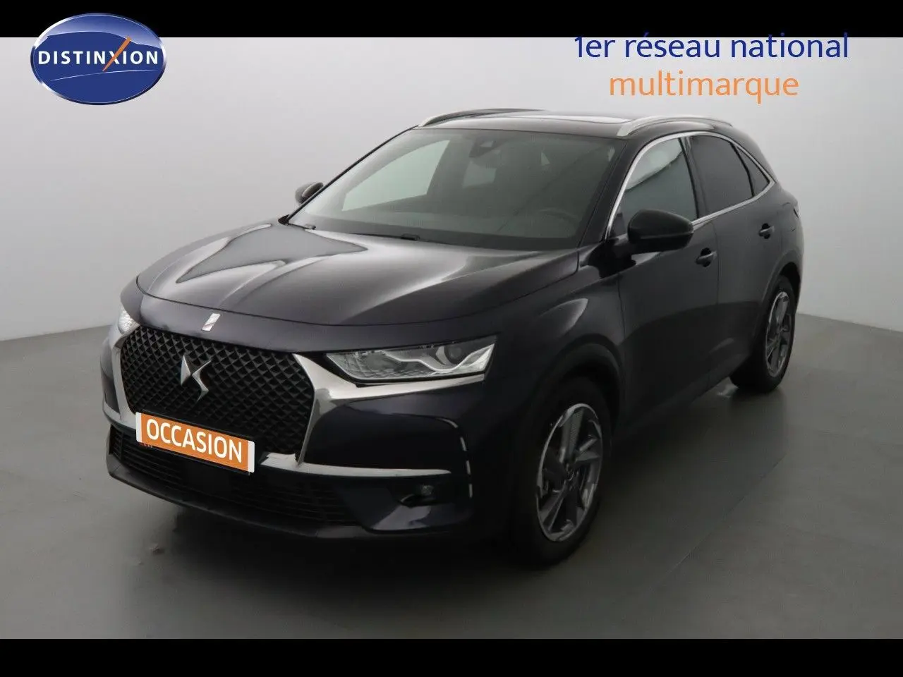 DS7 Crossback hybride rechargeable bleu encre métal vu en 3/4 avant droit avec calandre DS distinctive.