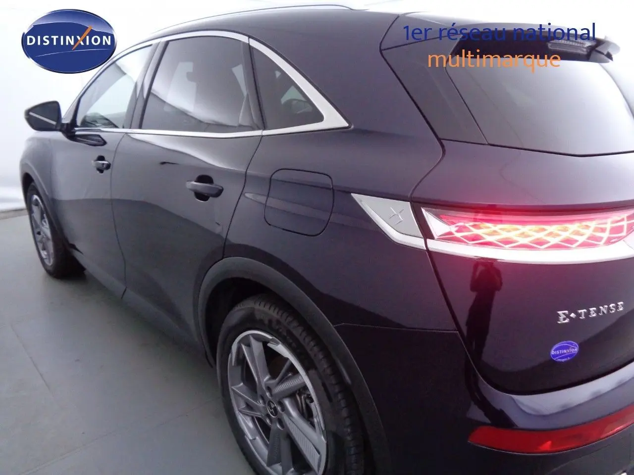 Vue 3/4 arrière droite d'un DS7 Crossback hybride rechargeable bleu encre métal avec feux arrière LED allumés.