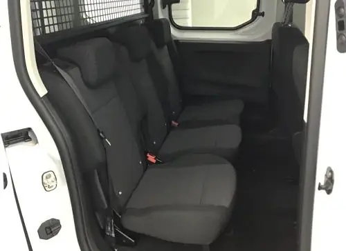 Vue intérieure côté droit du Peugeot Rifter blanc banquise 2025, montrant les sièges arrière noirs et la cloison métallique.