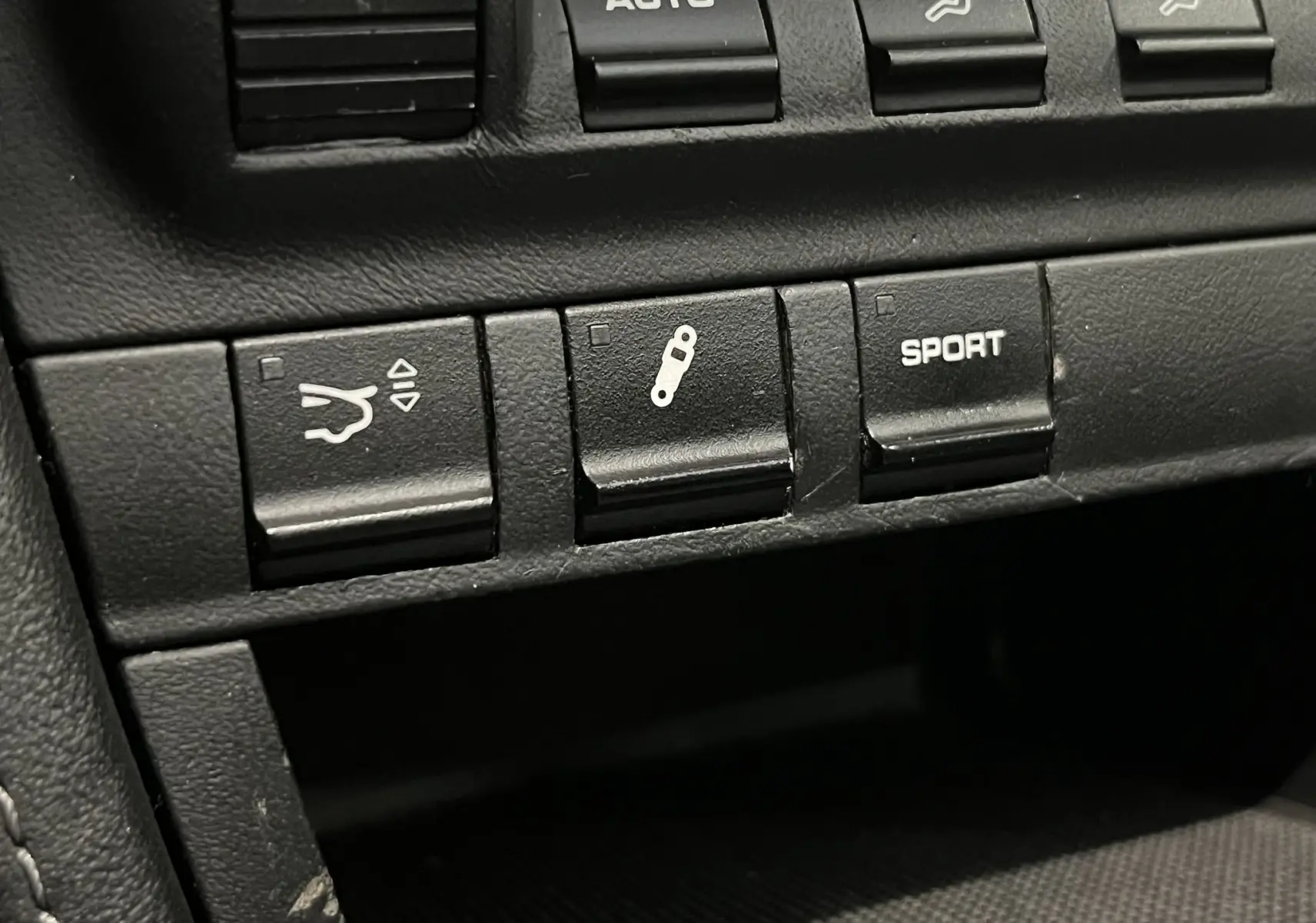 Gros plan sur les boutons de commande en cuir noir du tableau de bord de la Porsche 911 Targa 997 Carrera 4S.