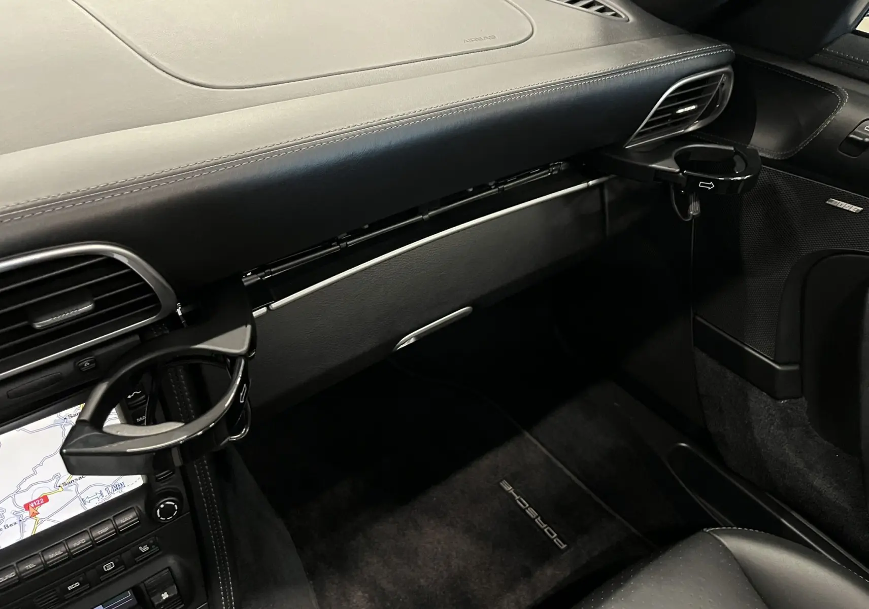 Intérieur noir de Porsche 911 Targa 997 Carrera 4S, vue sur tableau de bord et porte-gobelets déployés côté passager.