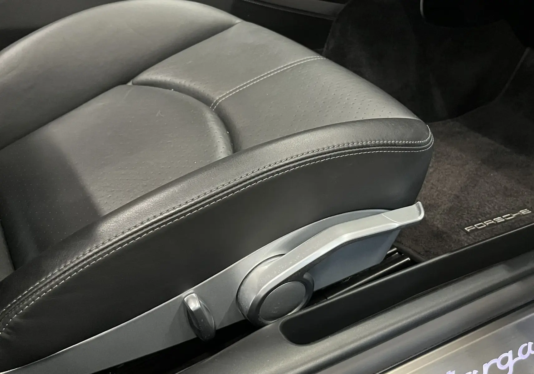 Gros plan sur le siège avant en cuir noir avec réglage manuel et seuil de porte éclairé Targa d'une Porsche 911 Targa 997 Carrera 4S.