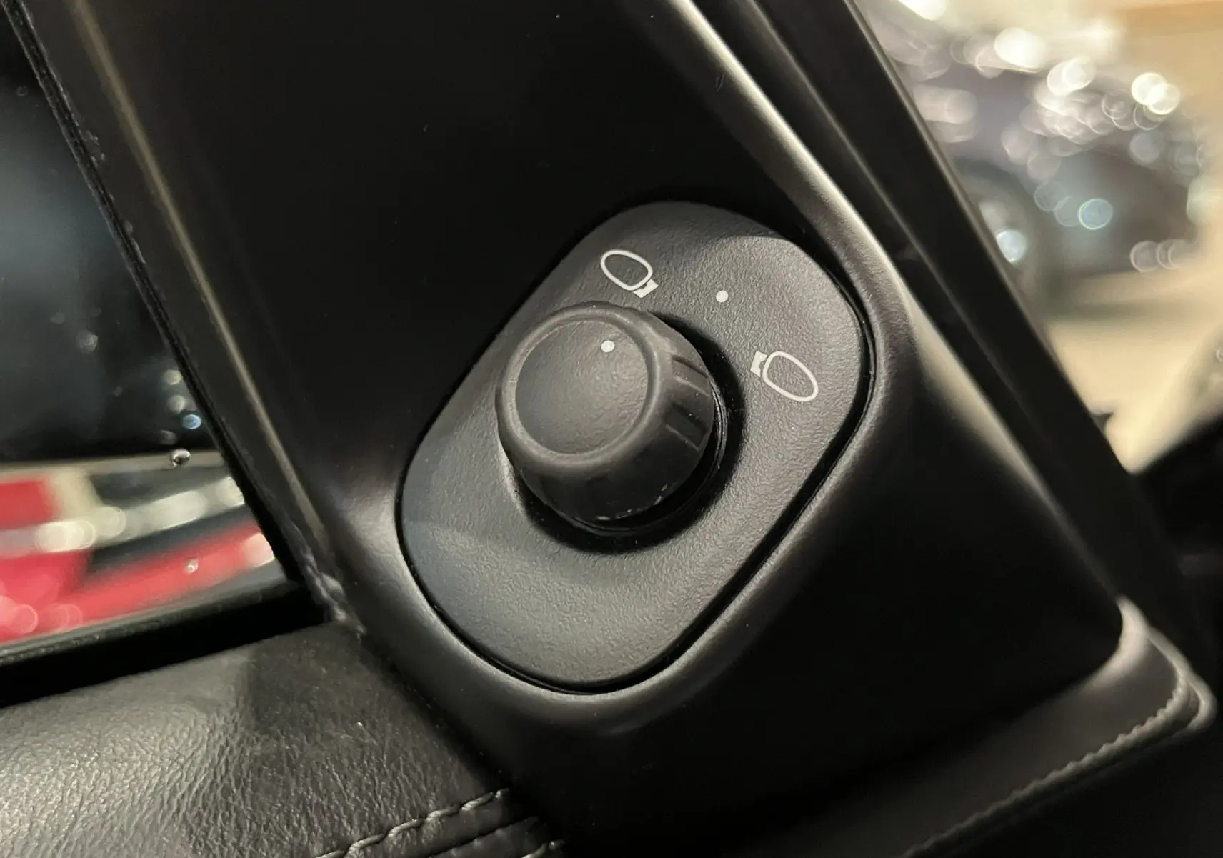 Gros plan sur le bouton de réglage des rétroviseurs intérieur noir dans une Porsche 911 Targa 997 Carrera 4S 2006.