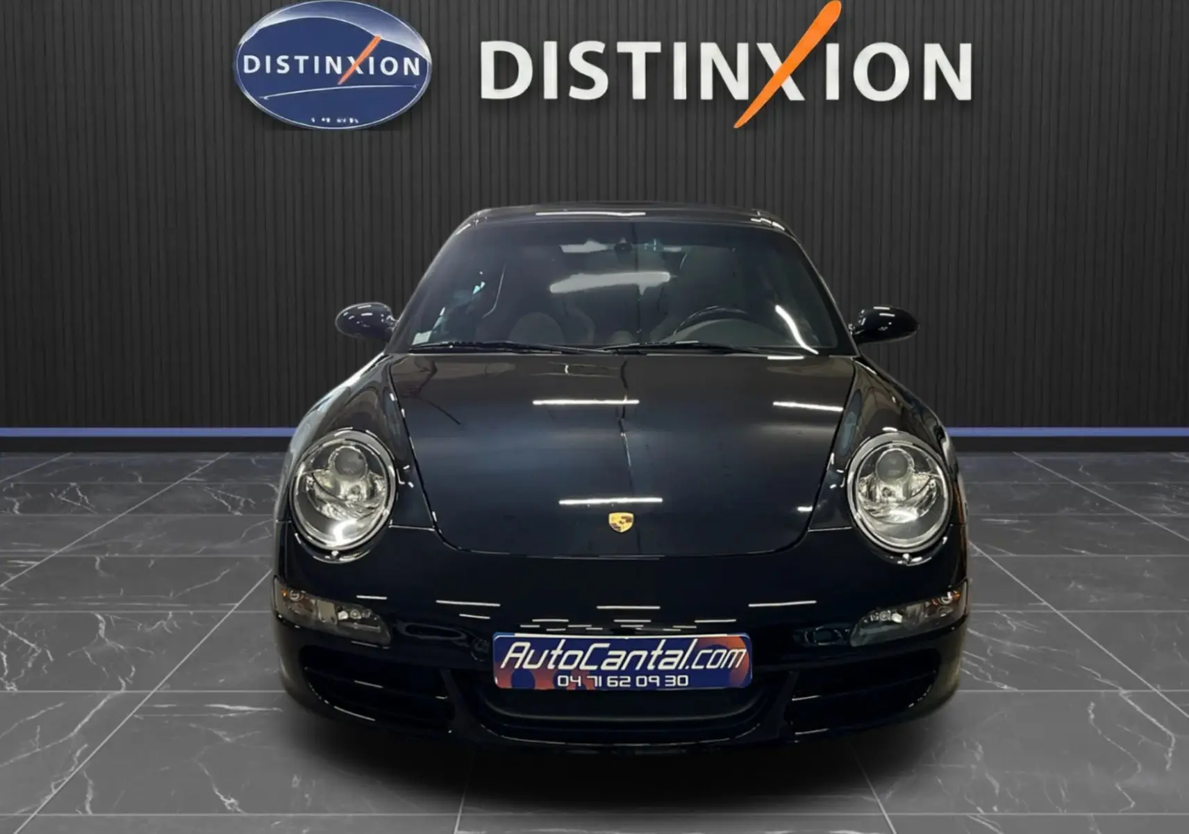 Vue de face d'une Porsche 911 Targa 997 Carrera 4S noire métallisée avec logo Porsche visible sur le capot.